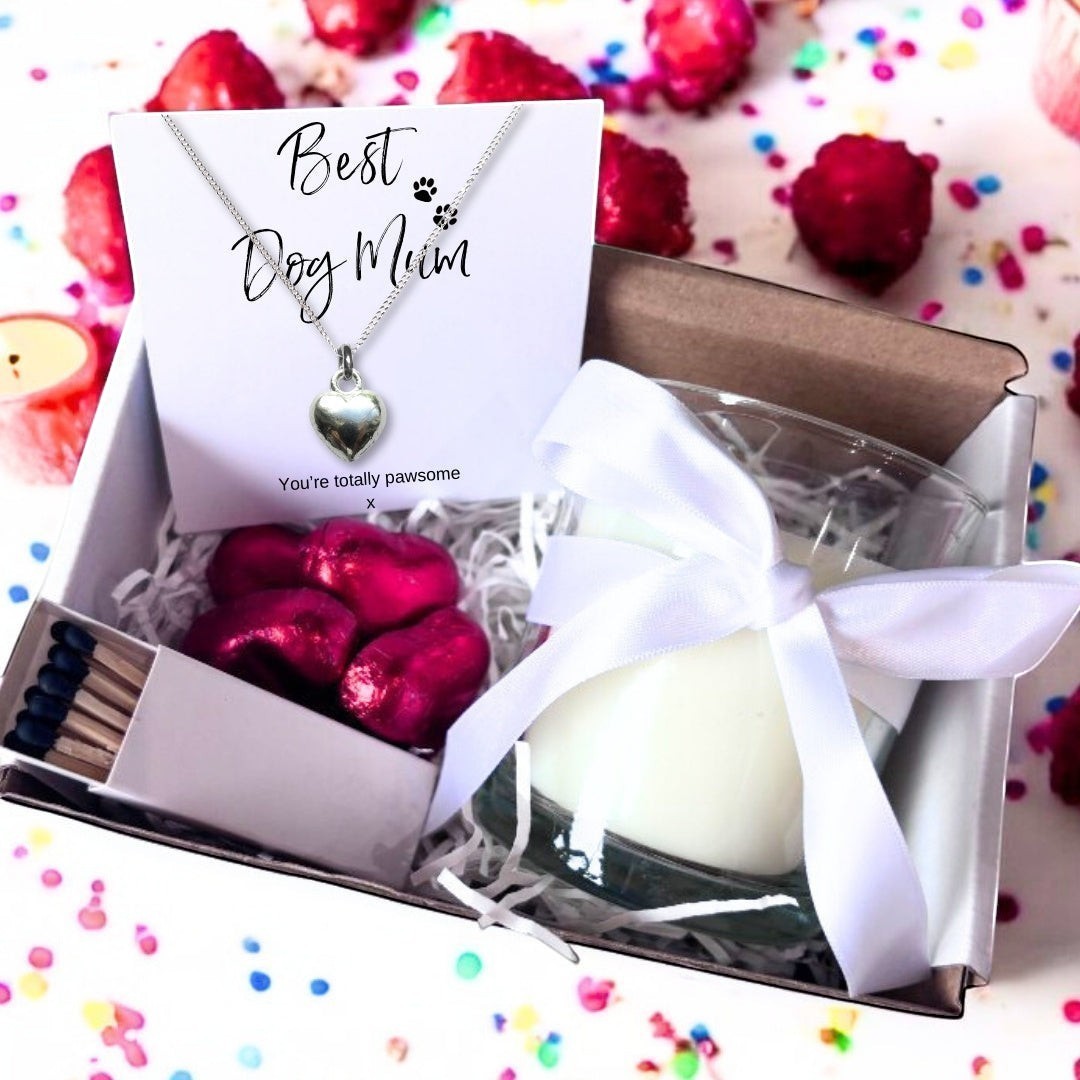 Best Dog Mum gift hamper contents showing the silver plated puff heart necklace on its Best Dog Mum card, a ribbon tied candle, matches and foil wrapped chocolate hearts