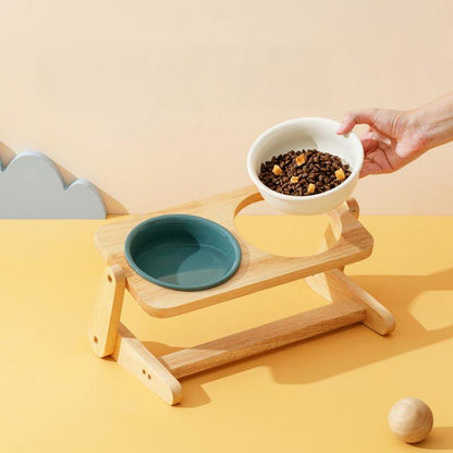 Hand placing a bowl of food into the raised wooden dog bowl stand