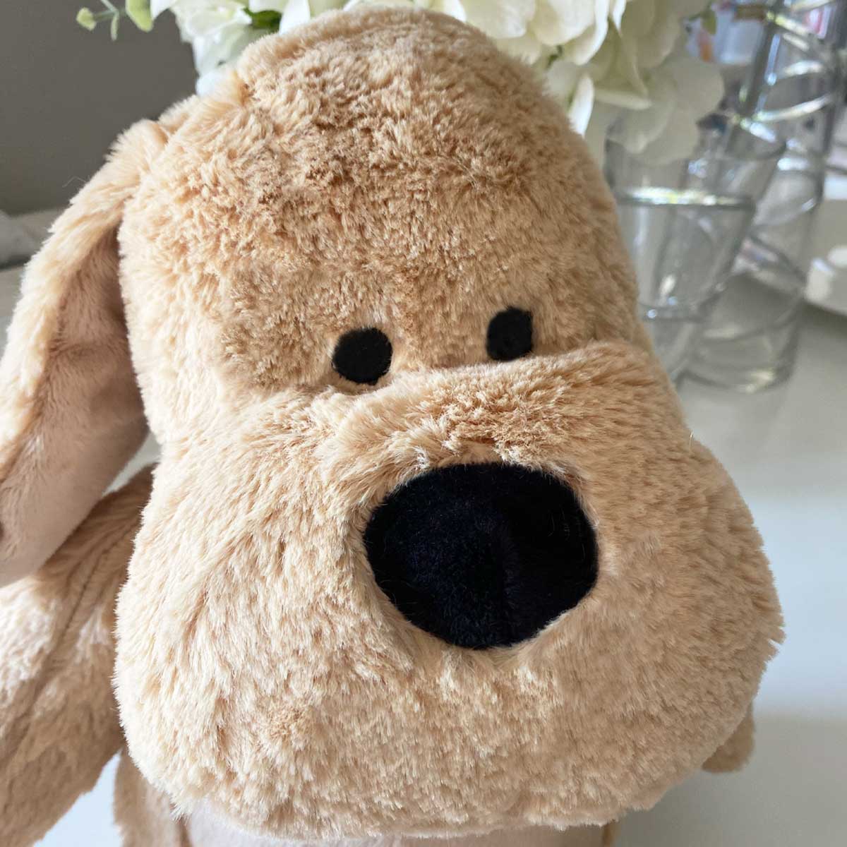 Close up of the embroidered heart and paw print on the comfort teddy