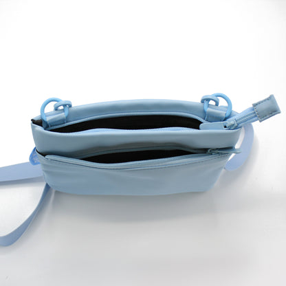 Baby blue crossbody dog walking bag opened to show its two zip compartments