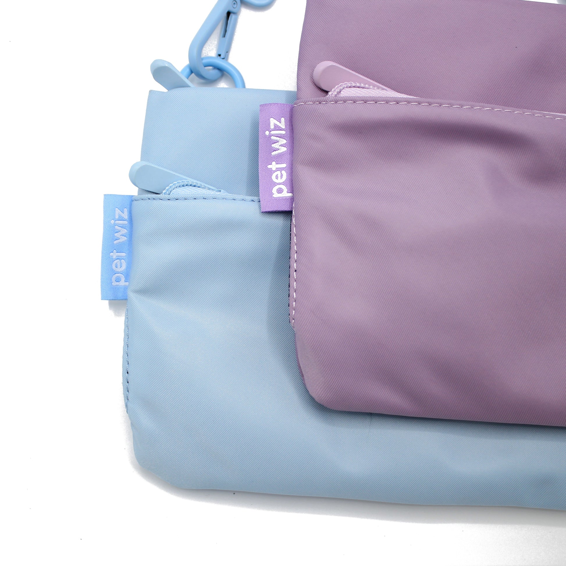 Lilac and baby blue crossbody dog walking bags side by side, Duke & Milo
