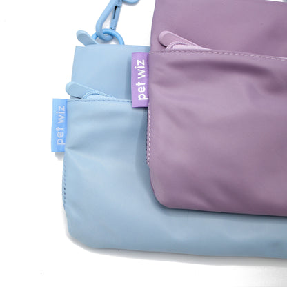 Lilac and baby blue crossbody dog walking bags side by side, Duke & Milo