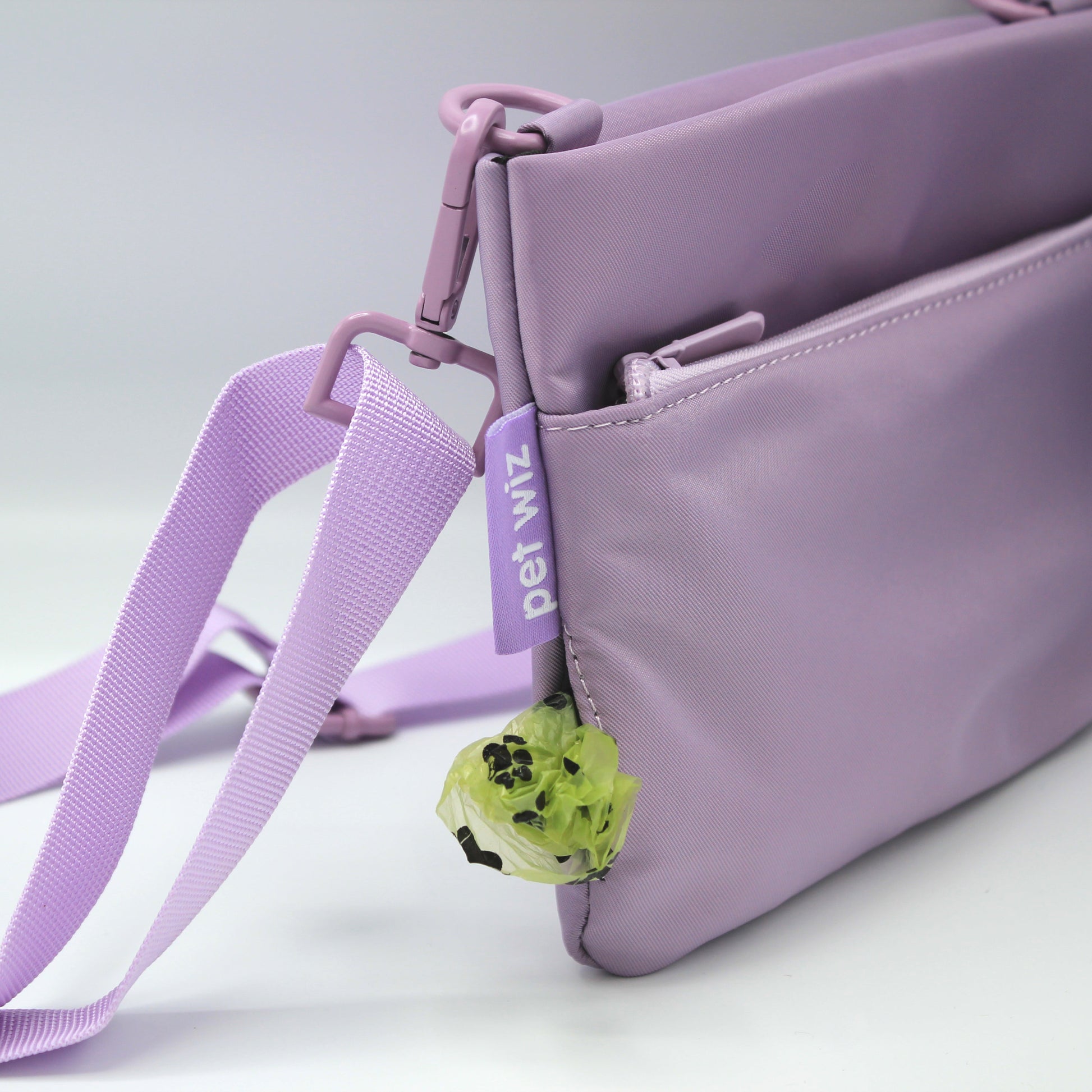 Close up of the lilac crossbody dog walking bag strap and side poo bag dispenser