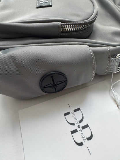 Close up of the grey nylon side panel on The PEBBLE, showing the waste bag dispenser opening