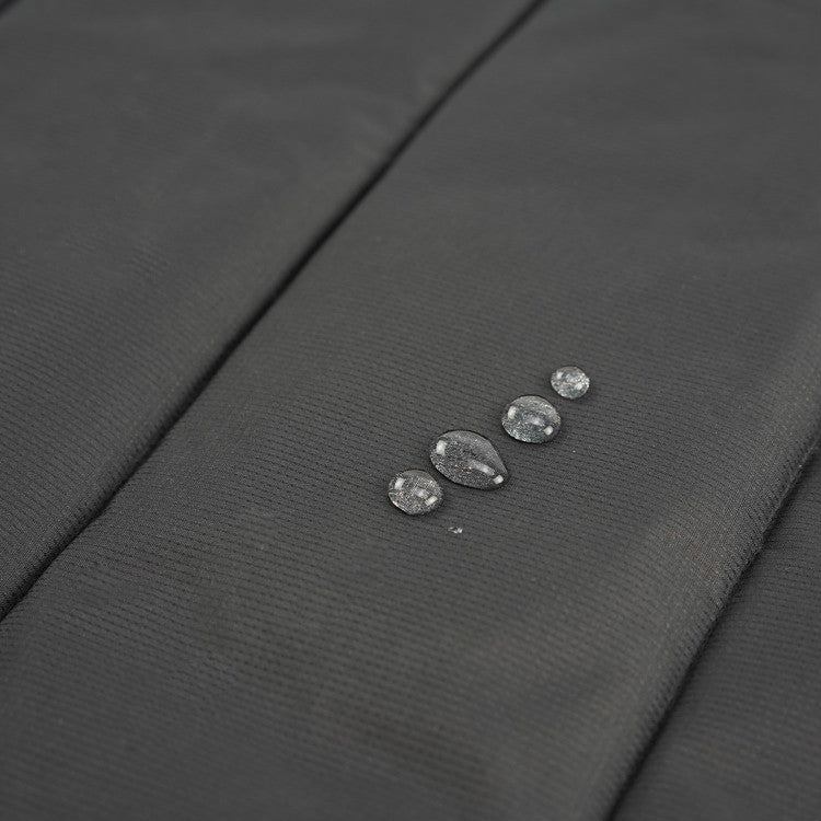 Close up of water beading on the dark water-resistant underside of the dog travel mat