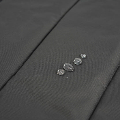 Close up of water beading on the dark water-resistant underside of the dog travel mat