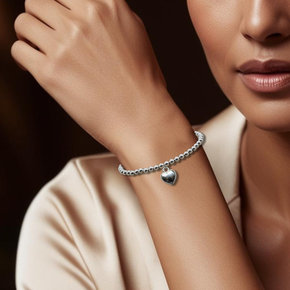 Woman wearing the silver plated beaded bracelet with a puff heart charm on her wrist